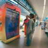 Consumidora utilizando tecnologia no ponto de venda com tela interativa em ambiente de varejo físico