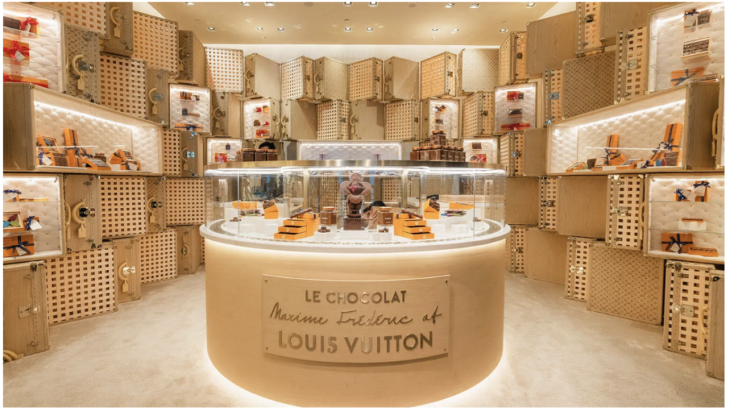 Espaço experiencial de fan zone no varejo da Louis Vuitton com exposição de produtos premium, design imersivo e ambiente de varejo de luxo focado na experiência do consumidor.